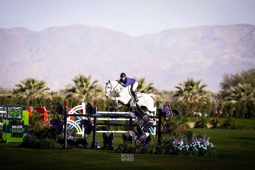 Emma Marlowe and a grey horse clearing a jump at Old Salem Farm
